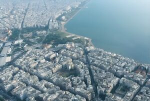 Aerial drone view of the dense urban coastline and residential buildings in Thessaloniki, Greece.